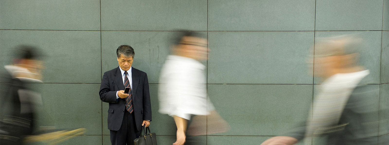 Man using phone on a busy district