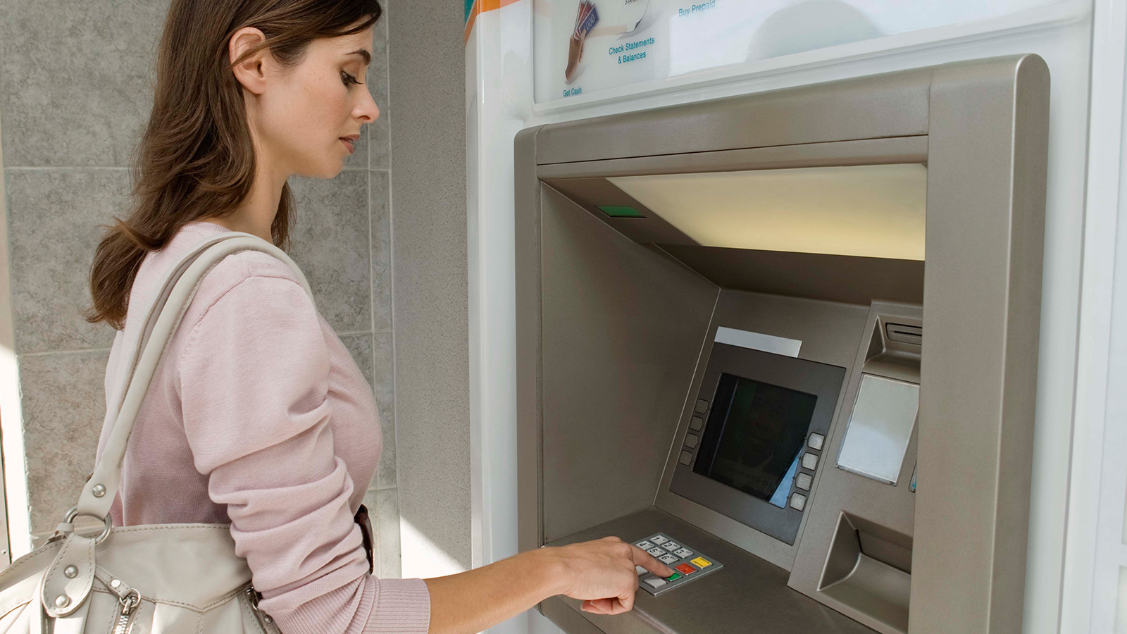 Woman standing at ATM.