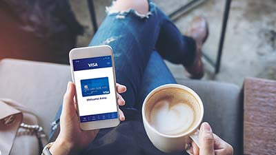 Woman looking at a Visa Digital card on a smartphone.