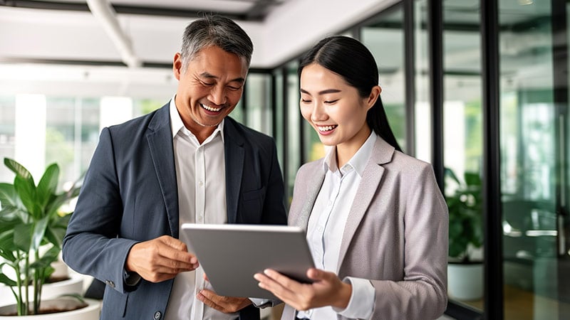 Two happy asian business people meeting at the office