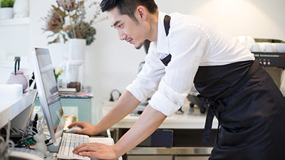 Coffee shop owner using computer