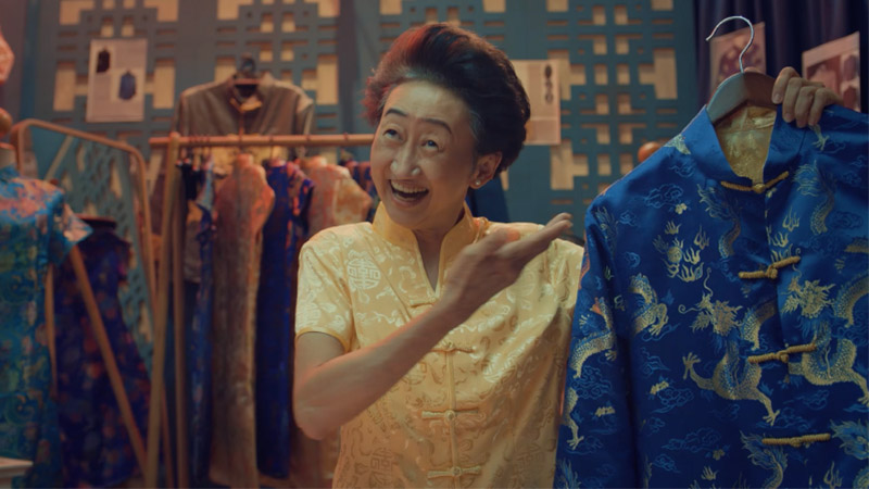 A woman on a market selling clothes, which can be paid for with a Visa travel card.