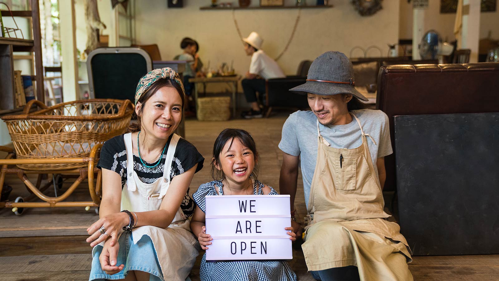 two adults and a child holding a sign