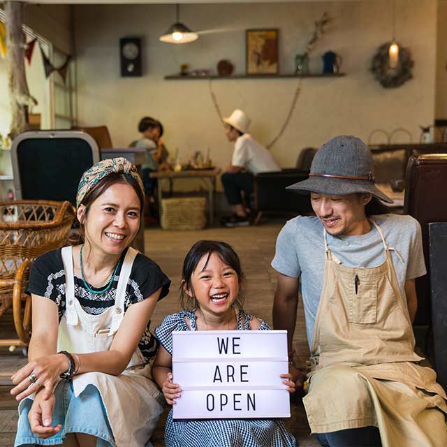 two adults and a child holding a sign